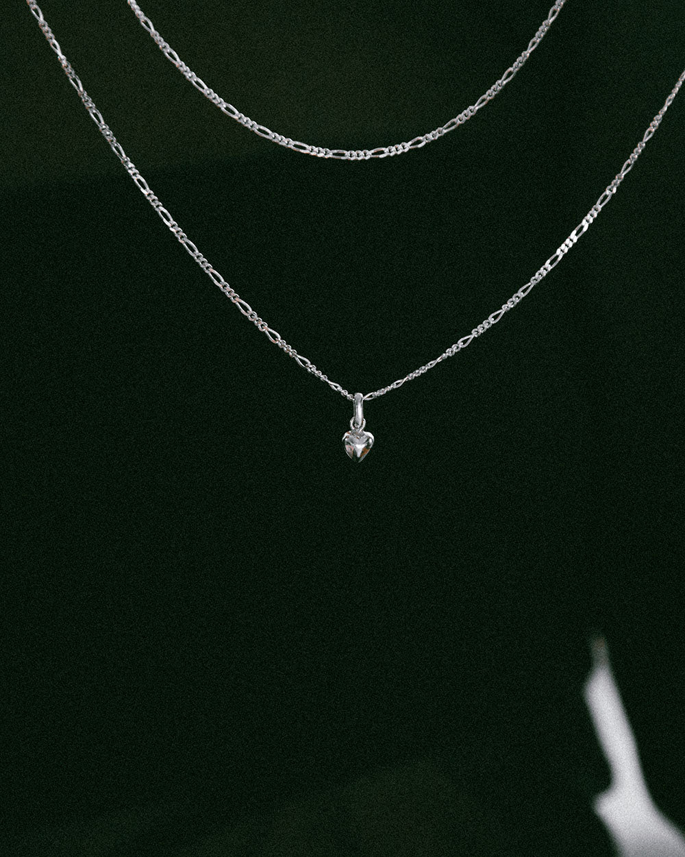 soft and sticky The tiniest, sweetest necklace. A miniature pendant for love inspired by a helium heart balloon. Strung on a classic figaro chain, choose from a 16"-22” chain.